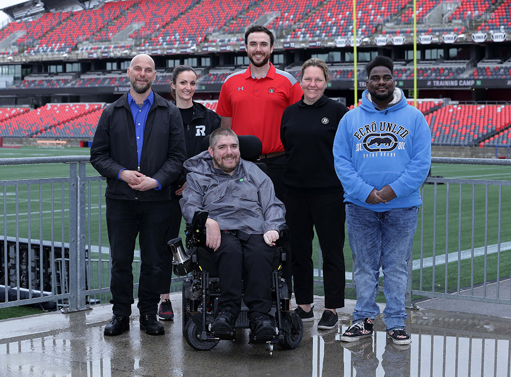 OSEG and PPRC Staff standing next to a football field.