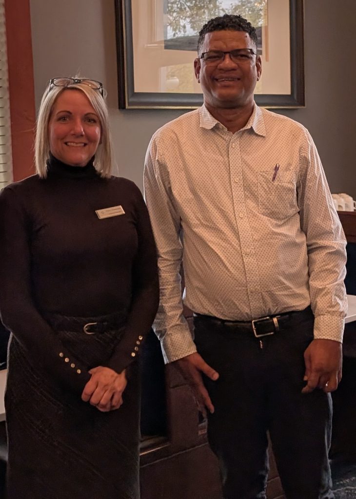 Deux personnes debout dans un restaurant posent pour une photo. Nancy Champagne discute avec Vilfort Metellus au sujet du travail dans l’industrie hôtelière.